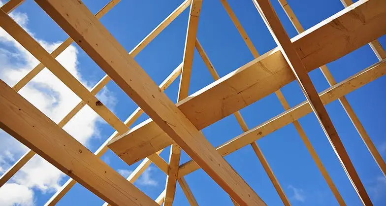 Ossature de toiture en bois contre le ciel bleu