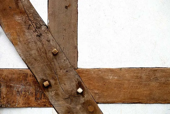 Assemblage de poutres anciennes sur une façade à colombages