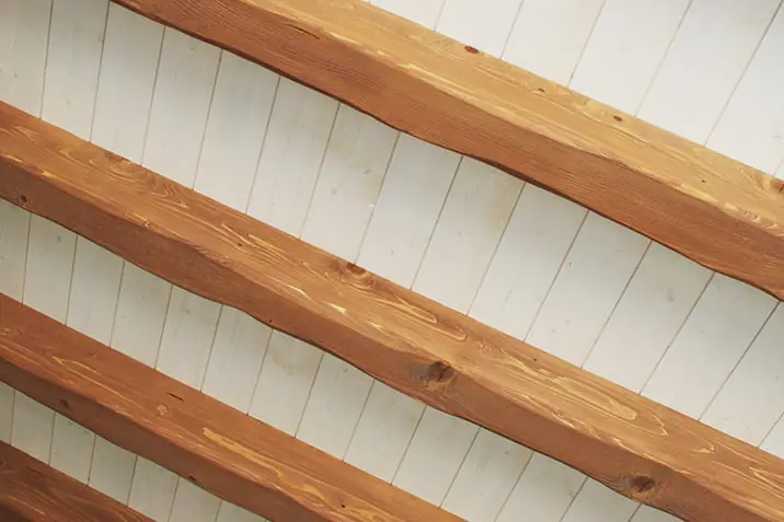 Poutres apparentes sous un plafond en bois